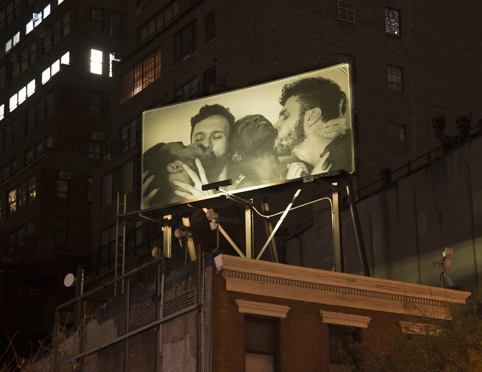 Camilo Godoy, AMIGXS (Self-portrait with Brendan, Carlos, and Jorge), 2017. Installation view at night of billboard produced by the International Studio & Curatorial Program (ISCP) at the Southeast corner of Ninth Avenue and 37th Street, Manhattan. Courtesy of the artist; PROXYCO Gallery, New York; and Dot Fiftyone Gallery, Miami.